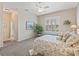 Well-lit bedroom with carpet, a large window, a king size bed, and a glimpse into the attached bathroom at 17599 Se 121St Cir, Summerfield, FL 34491