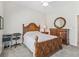 Bedroom with dark wood furniture, including bed, dresser and desk, with ceiling fan at 17599 Se 121St Cir, Summerfield, FL 34491