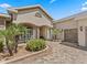 Inviting front entry featuring columns, a paver walkway, and lush landscaping at 17599 Se 121St Cir, Summerfield, FL 34491