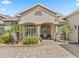 Charming front entry featuring columns, a decorative glass door, and lush landscaping at 17599 Se 121St Cir, Summerfield, FL 34491