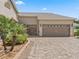 Spacious two-car garage with brick paver driveway and manicured landscaping at 17599 Se 121St Cir, Summerfield, FL 34491