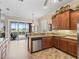 Kitchen with wooden cabinets, stainless steel appliances, and sliding glass doors leading to the outdoor patio at 17599 Se 121St Cir, Summerfield, FL 34491