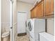 Well-lit laundry room equipped with front-loading washer and dryer, built-in cabinets, and neutral decor at 17599 Se 121St Cir, Summerfield, FL 34491