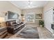 Comfortable living room with leather sofa, area rug and window with shutter at 17599 Se 121St Cir, Summerfield, FL 34491