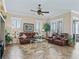 Inviting living room features stylish furniture, neutral walls, plantation shutters and a decorative ceiling fan at 17599 Se 121St Cir, Summerfield, FL 34491