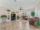Spacious living room with built-in shelving, a large-screen TV, neutral walls, and ceramic tile flooring at 17599 Se 121St Cir, Summerfield, FL 34491