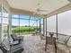 Screened in patio with decorative brick flooring, ceiling fan, dining table, and outdoor seating overlooking the green yard at 17599 Se 121St Cir, Summerfield, FL 34491
