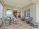 Covered patio with tile flooring, ceiling fan, dining table, and outdoor seating overlooking a view of the yard at 17599 Se 121St Cir, Summerfield, FL 34491