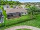 Aerial view of the rear exterior of the home showcasing the screened patio and manicured lawn at 17599 Se 121St Cir, Summerfield, FL 34491