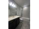 Well lit bathroom with double vanity with quartz countertop, a bathtub, and neutral tile at 2064 Asher Ave, Minneola, FL 34715