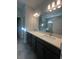 Modern bathroom featuring double vanity with quartz countertop and a glass-enclosed shower at 2064 Asher Ave, Minneola, FL 34715