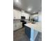 Stylish kitchen with stainless steel appliances, a large island, white cabinets and tile floors at 2064 Asher Ave, Minneola, FL 34715