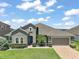 Charming one-story home boasts a manicured lawn, two-car garage, and a blue entry door at 2136 Lula Rd, Minneola, FL 34715