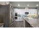 Modern kitchen features white cabinets, stainless steel appliances, a stylish backsplash, and granite countertops at 2136 Lula Rd, Minneola, FL 34715