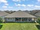 Beautiful backyard view of the home featuring a covered patio, well-maintained lawn and manicured landscaping at 2136 Lula Rd, Minneola, FL 34715