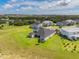 Aerial view of the home's spacious backyard surrounded by lush greenery and neighboring homes in the distance at 2161 Cedar Springs Way, Minneola, FL 34715