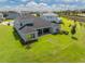Aerial view of a home's backyard, featuring a lush lawn and a covered patio perfect for outdoor living at 2161 Cedar Springs Way, Minneola, FL 34715