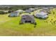 Aerial view of a home's backyard, featuring a lush lawn and a covered patio perfect for outdoor living at 2161 Cedar Springs Way, Minneola, FL 34715