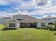 Back exterior view of home featuring covered patio and manicured lawn at 2161 Cedar Springs Way, Minneola, FL 34715