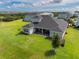 Aerial view showcases a home's covered patio, expansive lawn, and tasteful landscaping in a desirable neighborhood at 2161 Cedar Springs Way, Minneola, FL 34715