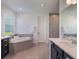 A luxurious bathroom with a soaking tub, double vanity, and bright lighting at 2161 Cedar Springs Way, Minneola, FL 34715