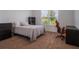 Neutral bedroom featuring a large window, a bed with a comfy gray quilt, and an office setup at 2161 Cedar Springs Way, Minneola, FL 34715
