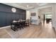 Elegant dining area featuring stylish lighting, a dark accent wall, and wood-look flooring at 2161 Cedar Springs Way, Minneola, FL 34715