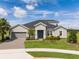 Beautiful single-Gathering home featuring manicured lawn, blue front door, and two car garage at 2161 Cedar Springs Way, Minneola, FL 34715