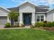 This home features an eye catching blue front door and lush landscaping with fresh mulch at 2161 Cedar Springs Way, Minneola, FL 34715