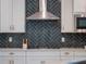 Close-up on kitchen details, showing a dark backsplash, stainless hood, and modern appliances for cooking at 2161 Cedar Springs Way, Minneola, FL 34715