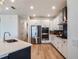 Well-lit modern kitchen with stainless steel appliances, dark backsplash, and sleek countertops, ideal for cooking and dining at 2161 Cedar Springs Way, Minneola, FL 34715