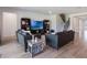 Bright living room with gray couches, wood floors, TV, and staircase at 2161 Cedar Springs Way, Minneola, FL 34715