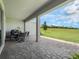 Covered patio with stylish furniture overlooking an expansive grassy lawn at 2161 Cedar Springs Way, Minneola, FL 34715