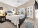 Relaxing bedroom featuring a dark metal bed frame, soft carpeting, and bright natural lighting at 2465 Violet Ct, The Villages, FL 32162