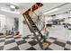 Functional garage with black and white flooring and pull-down attic access ladder at 2465 Violet Ct, The Villages, FL 32162