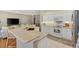 Open kitchen features an eat-in bar, white cabinets and stainless steel appliances at 2465 Violet Ct, The Villages, FL 32162
