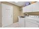 Well-equipped laundry room with sink, cabinets, washer, and dryer for convenient chores at 2465 Violet Ct, The Villages, FL 32162