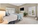 Cozy main bedroom with white shutters, ceiling fan, light gray carpet, and mounted television at 2465 Violet Ct, The Villages, FL 32162