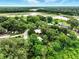 An aerial view showcases the property nestled among lush greenery with a glimpse of the lake beyond at 25888 Se 157Th Ln, Umatilla, FL 32784