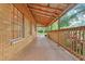 Covered patio showcasing a wood railing, ample space, and view to backyard at 25888 Se 157Th Ln, Umatilla, FL 32784