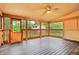 Cozy screened porch with wood flooring and ceiling fan, perfect for outdoor relaxation at 25888 Se 157Th Ln, Umatilla, FL 32784