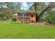 Back porch featuring wood accents and a screen, all surrounded by lush greenery at 25888 Se 157Th Ln, Umatilla, FL 32784