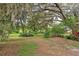 Lush green backyard featuring trees covered with Spanish moss at 25888 Se 157Th Ln, Umatilla, FL 32784