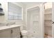 Bathroom featuring a shower, toilet, sink with granite top, shelves and a window at 25888 Se 157Th Ln, Umatilla, FL 32784