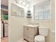 Bathroom featuring a sink, toilet, mirror and a window at 25888 Se 157Th Ln, Umatilla, FL 32784