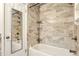 Bathroom with a white bathtub with grey tile, mirror and white door at 25888 Se 157Th Ln, Umatilla, FL 32784