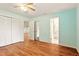 Bedroom featuring wood-look floors, closet, and views to the en-suite bathroom and living room at 25888 Se 157Th Ln, Umatilla, FL 32784
