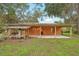 Rear of house showcasing covered parking and spacious outdoor area with a well-maintained lawn at 25888 Se 157Th Ln, Umatilla, FL 32784