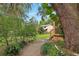 Backyard home exterior showcasing a peaceful setting with lush greenery and a quaint path at 25888 Se 157Th Ln, Umatilla, FL 32784