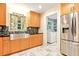 Charming kitchen features a stainless steel sink, updated cabinets, and a view into the laundry room at 25888 Se 157Th Ln, Umatilla, FL 32784